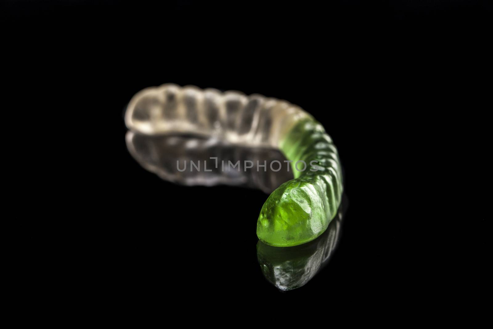 Jelly worm isolated on black background with reflexion