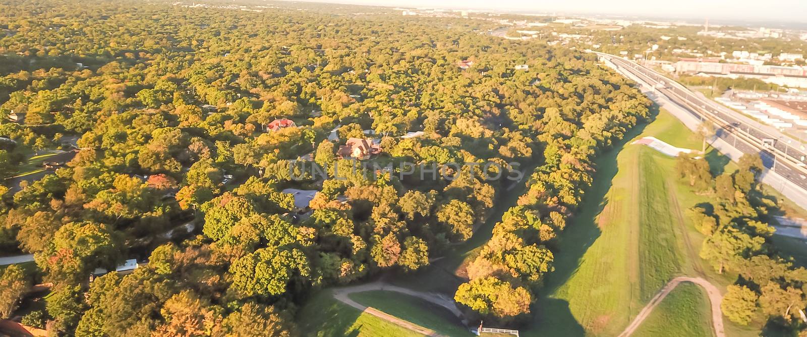 Panorama aerial view Kessler Park near Highway 30 south of downtown Dallas, Texas, USA. Flyover green neighborhood with mature trees and rolling hill terrain