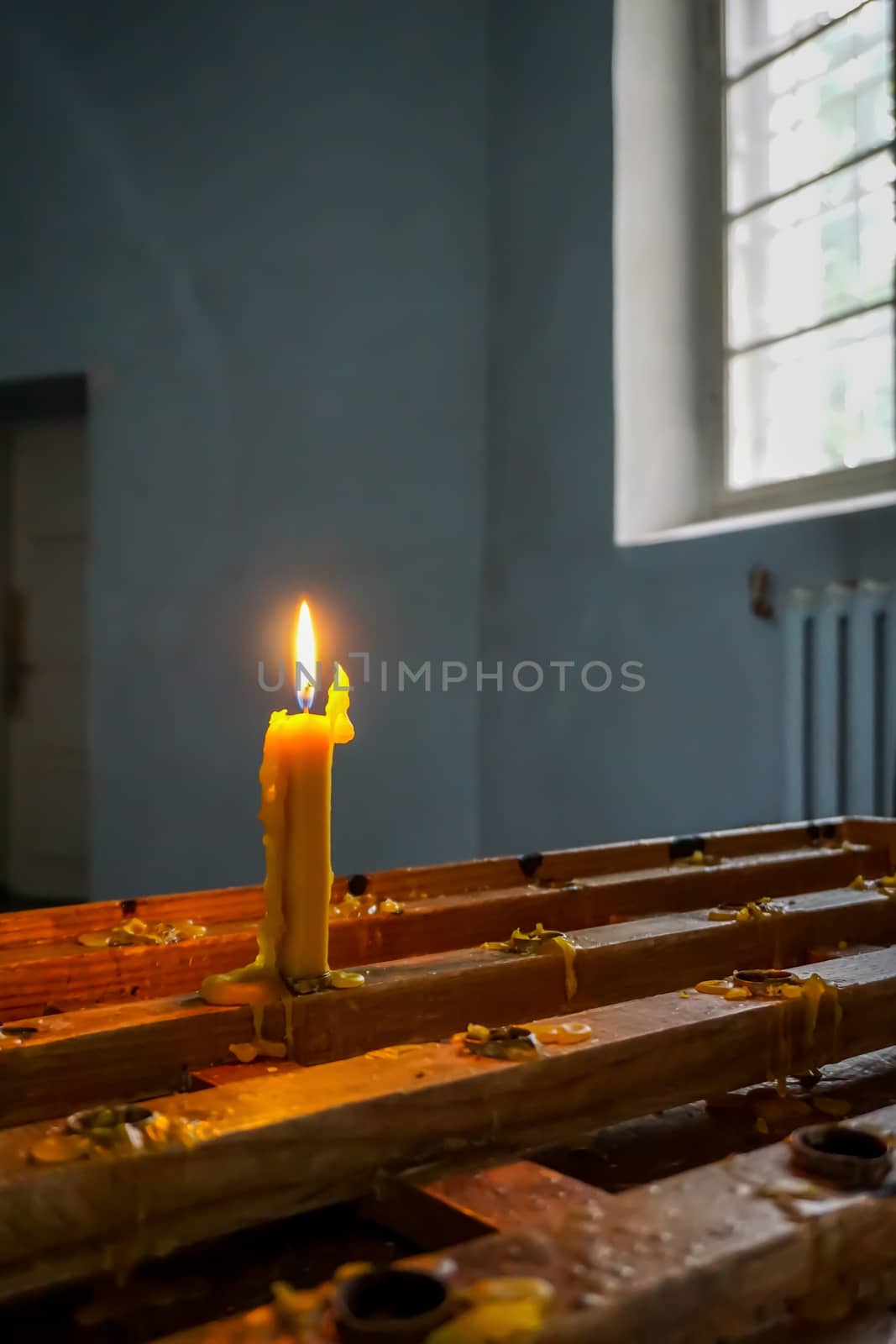 Burning candle at Koknese Evangelical Lutheran Church. Evangelic Lutheran Church in Koknese, Latvia. Interior of Koknese church. Church was built in 1687. 