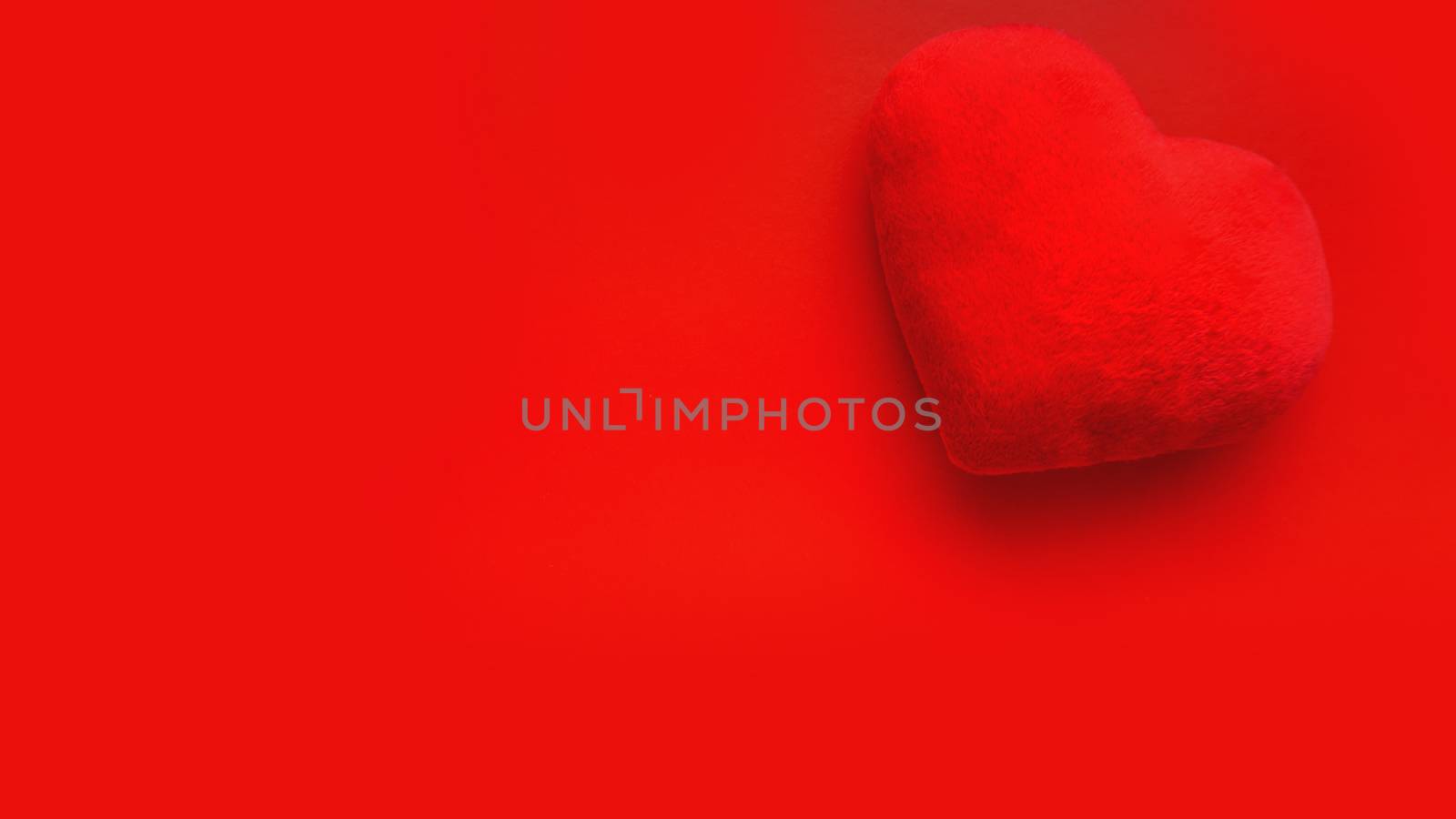 Valentines day love background with soft toy heart on red background. Top view. For banner, cards design