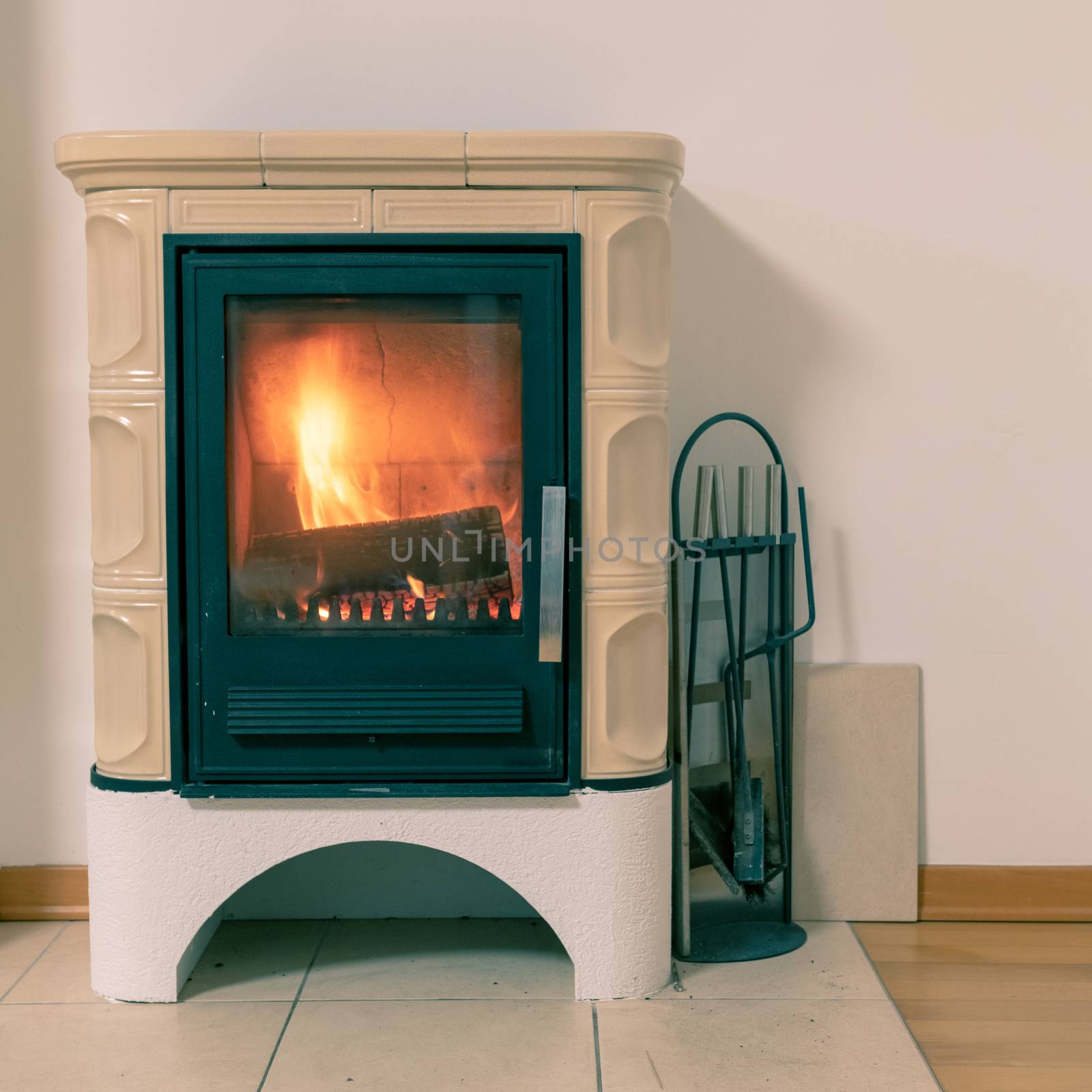 Tiled stove with fire burning inside by asafaric