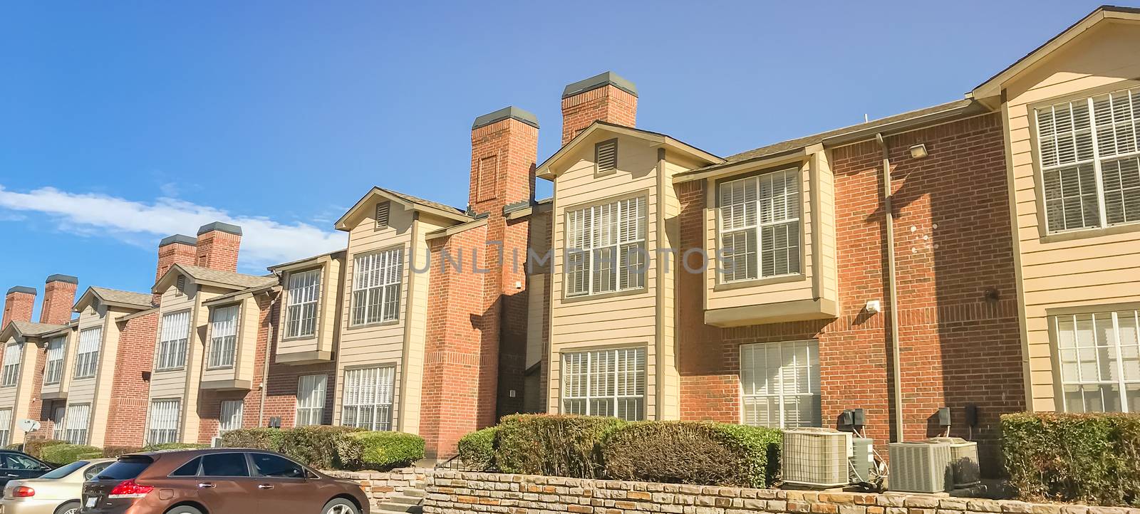 Panorama view typical apartment complex near Dallas, Texas, USA with uncovered parking lots and high retaining wall