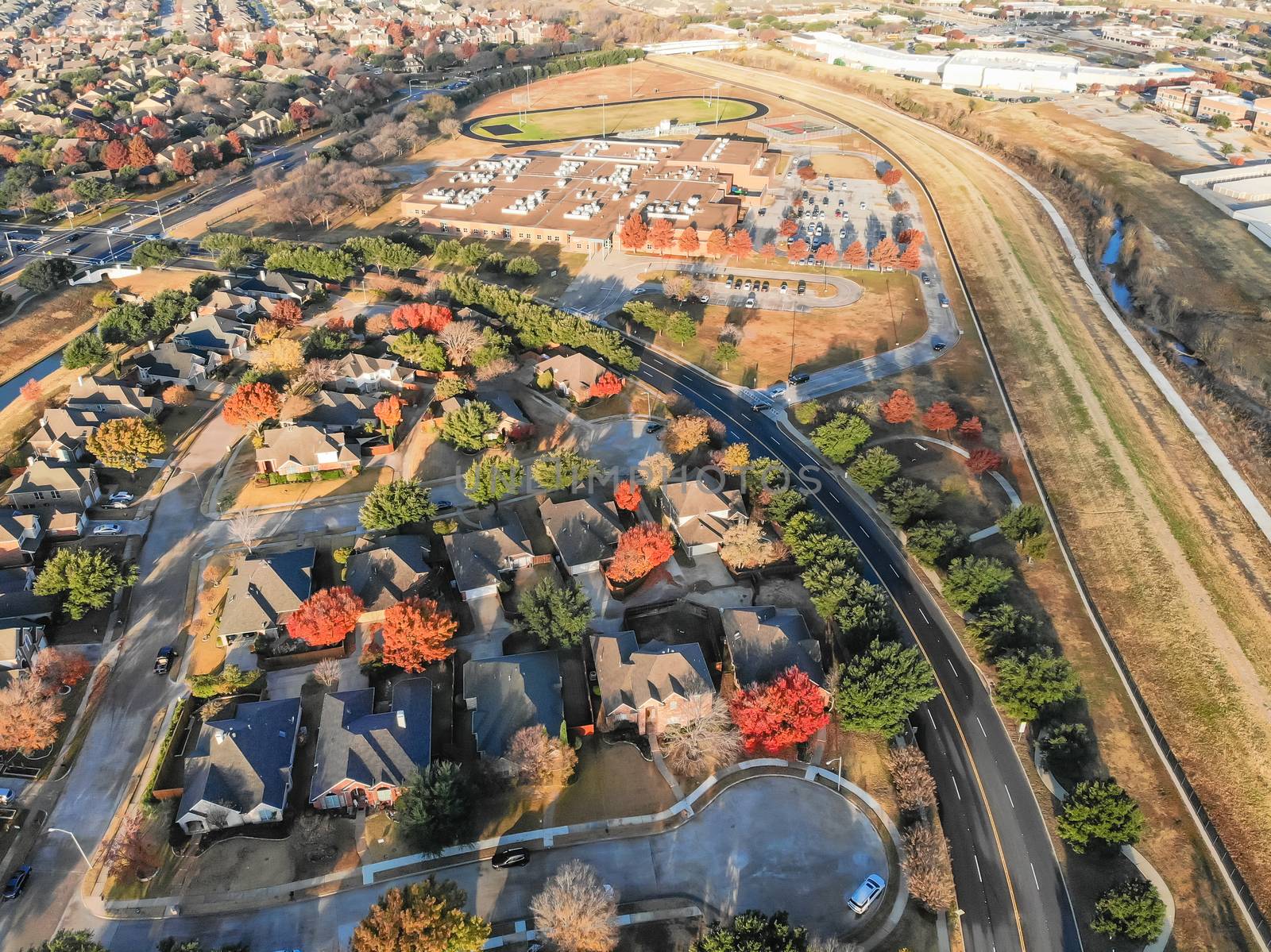 Aerial view parkside neighborhood with cul-de-sac dead-end street near Dallas, Texas. Flyover urban sprawl in autumn morning with colorful fall foliage leaves