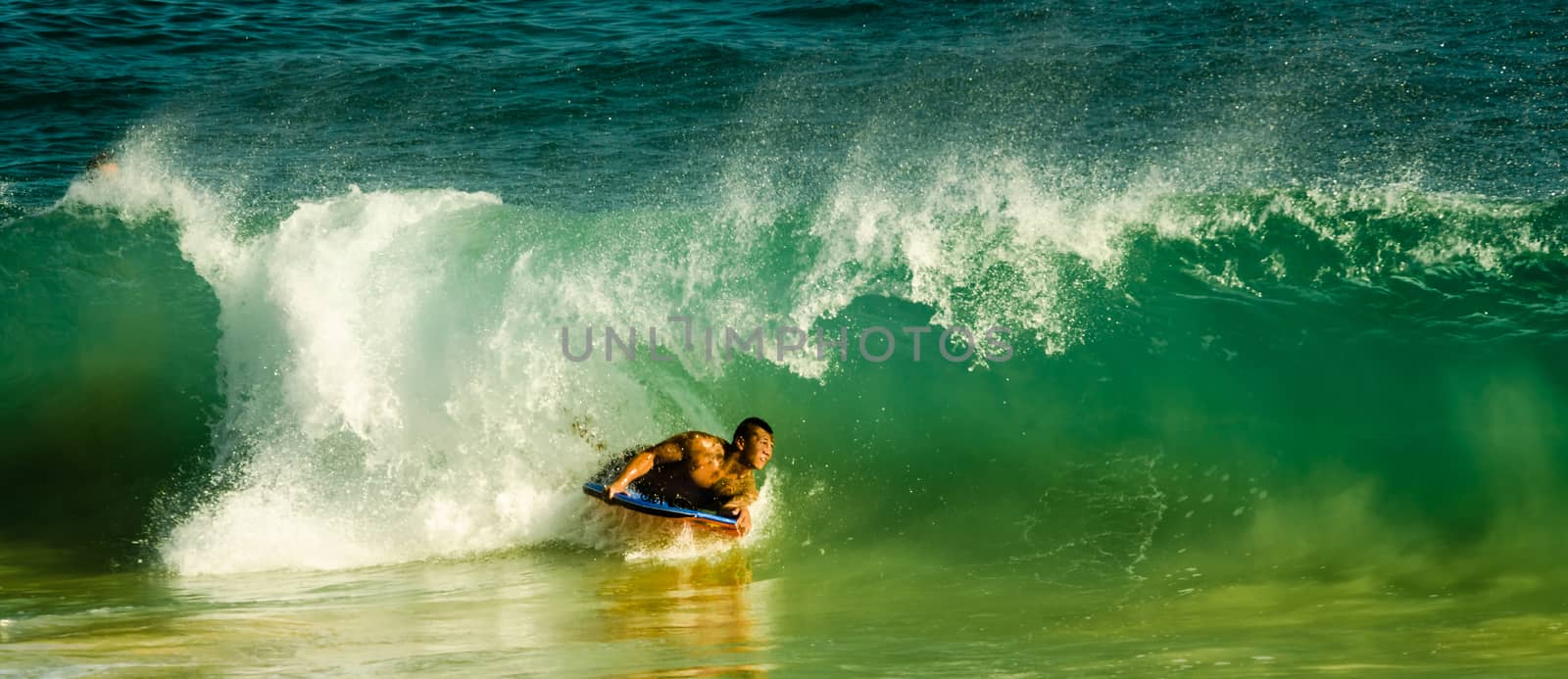 Young man surfs a wave with his short board in Hawaii, US by mikelju