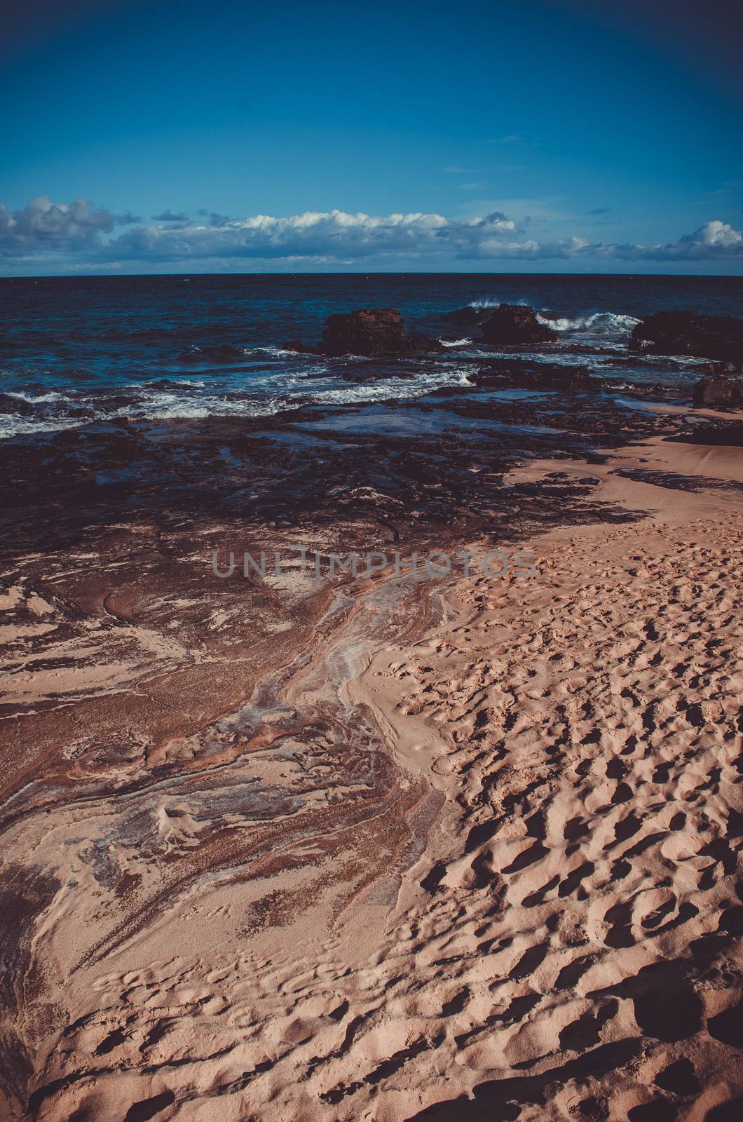 Sand, volcanic rock and water in Hawaii, US by mikelju