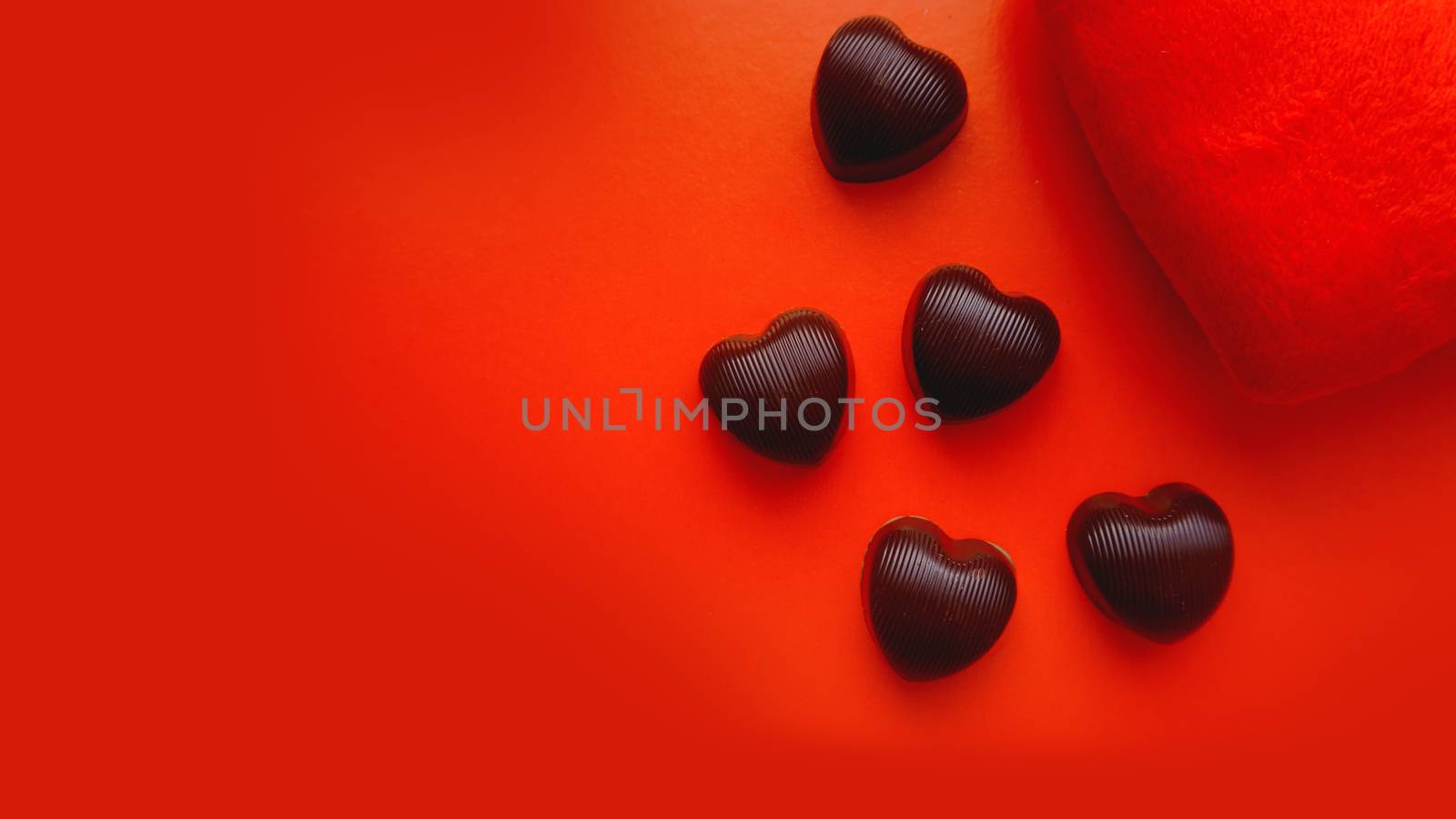 Valentines day background with soft toy heart and chocolates on red background by natali_brill