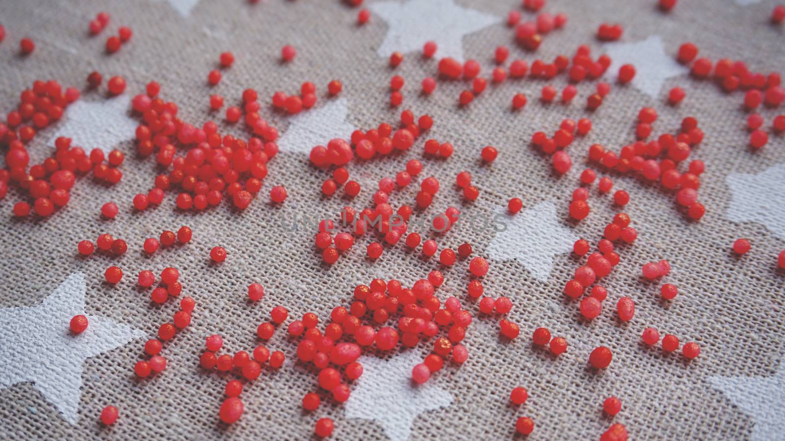 Red balls. Small gel ball. Silica gel. Balls of red hydrogel. Crystal liquid ball with reflection. Gray Texture background.