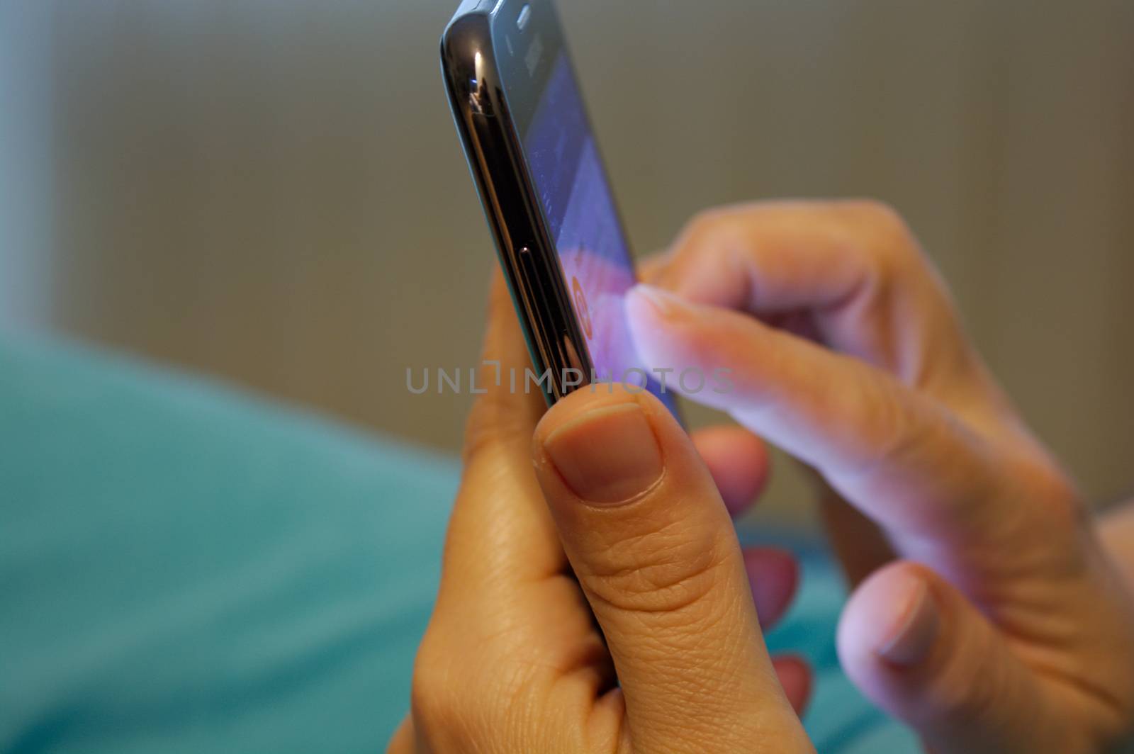 Close up of woman using mobile smart phone typing on the mobile phone keyboard or simply scrolling her emails