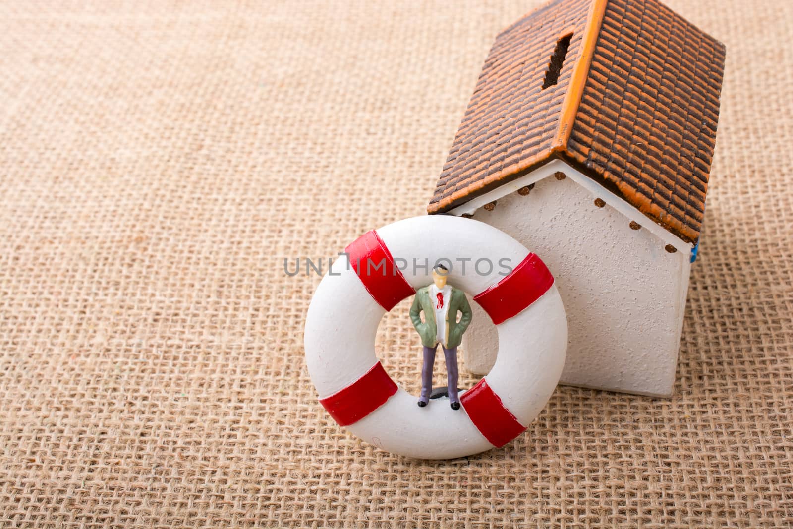 Model house and a life preserver with a man figure on it