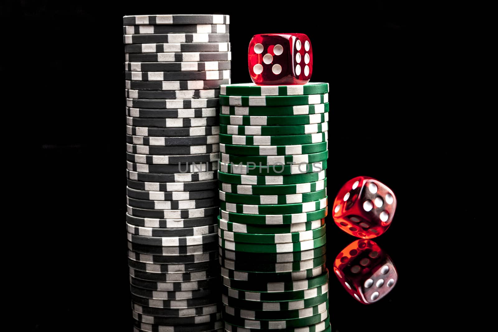 Dice and chips isolated on black background with reflexion