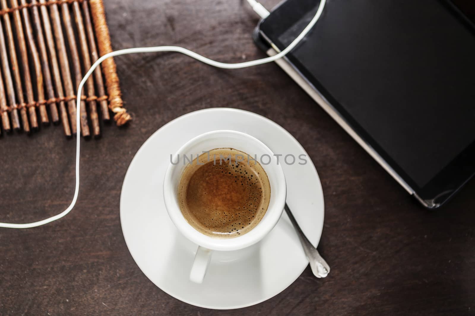 White cup filled with delicious coffe and a pad