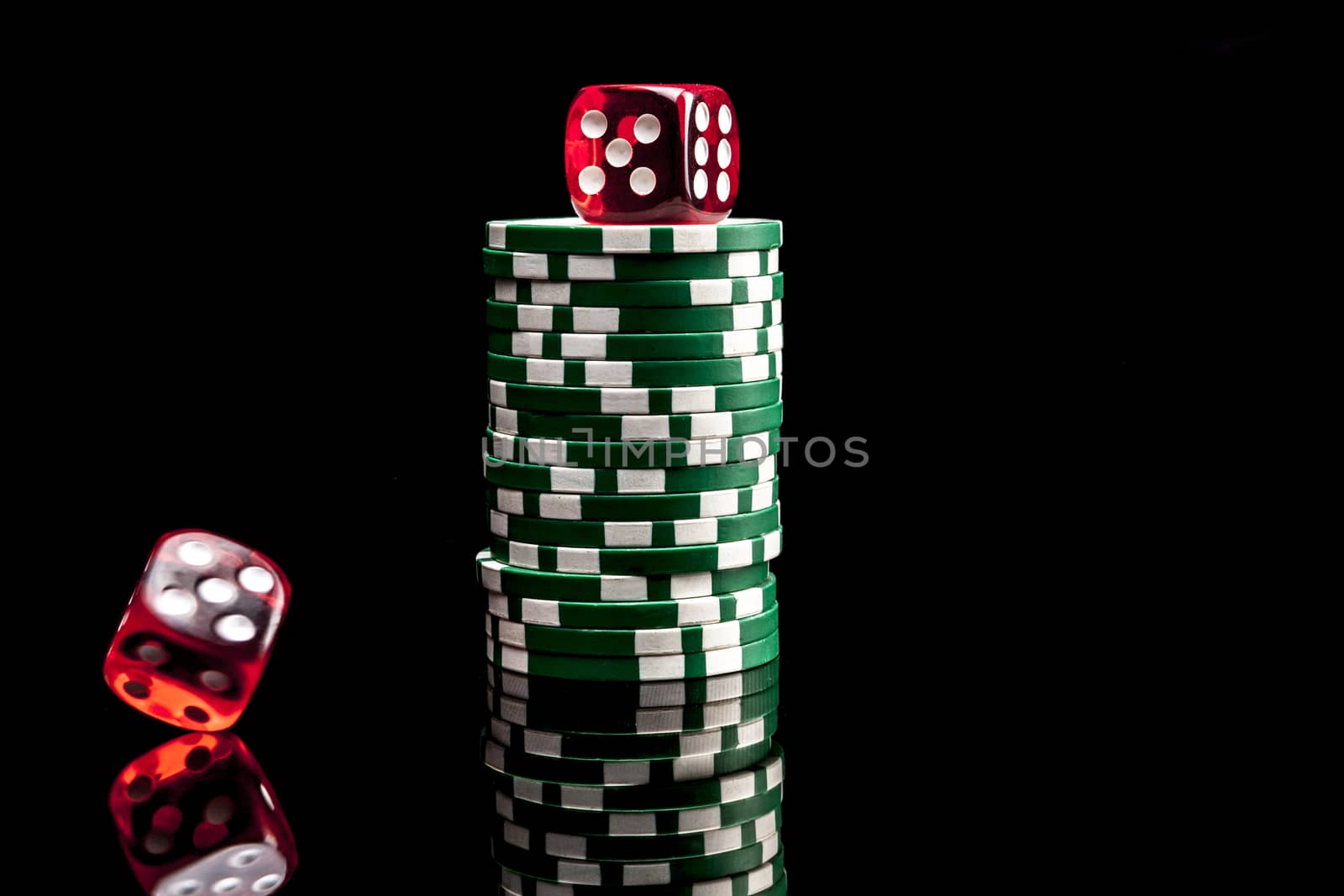 Dices and chips isolated on black background with reflexion