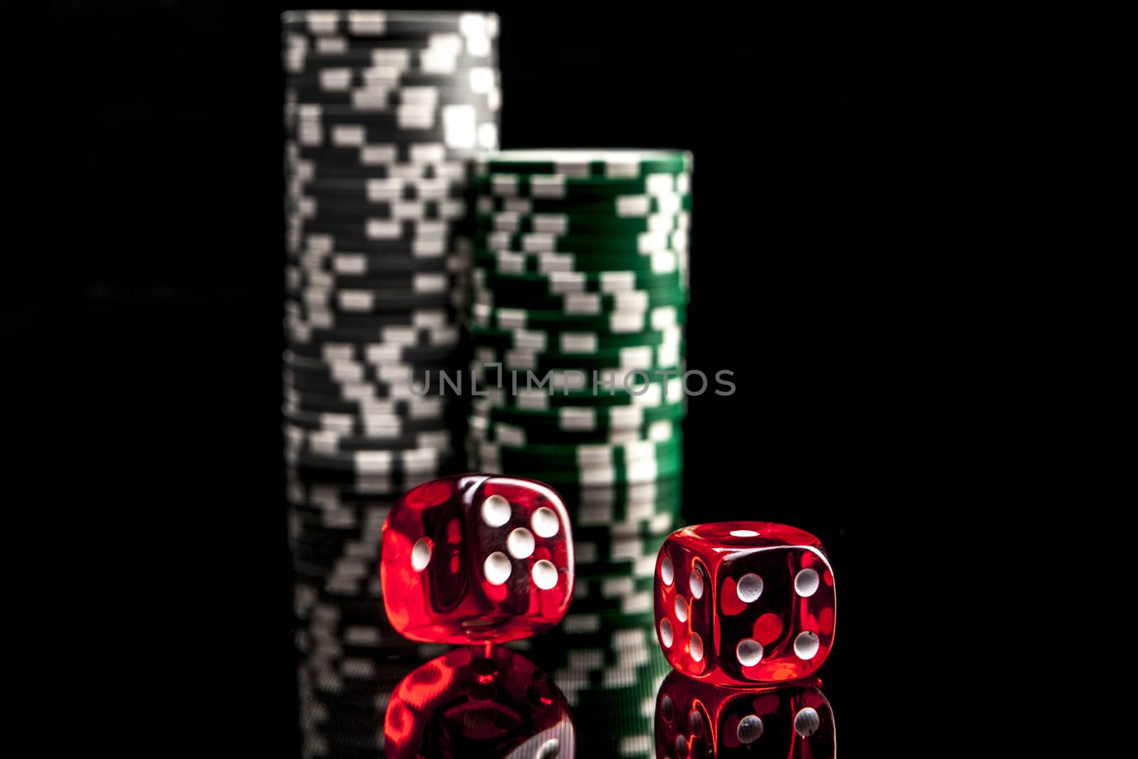 Dice and chips isolated on black background with reflexion