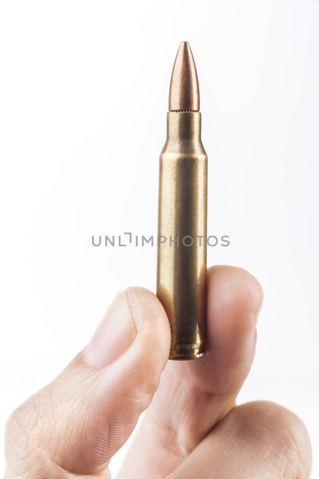 Fingers Holding Single Rifle Bullet Isolated On White Background