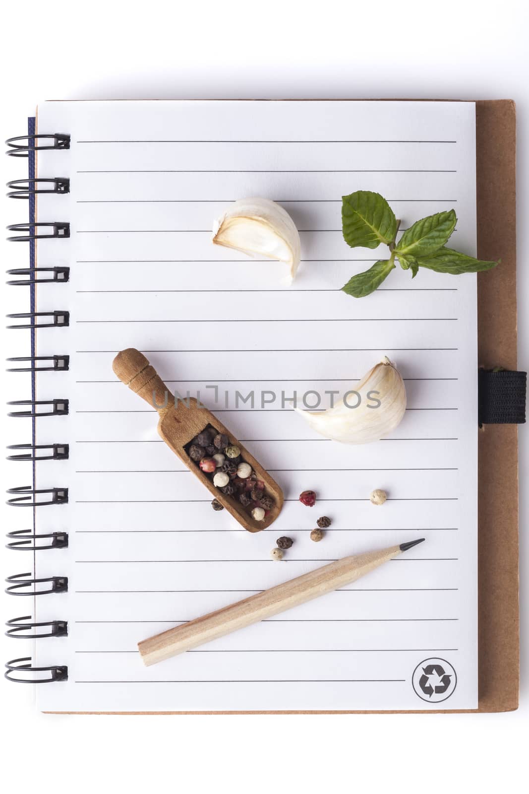Pencil on Notebook With Garlick and Black Pepper