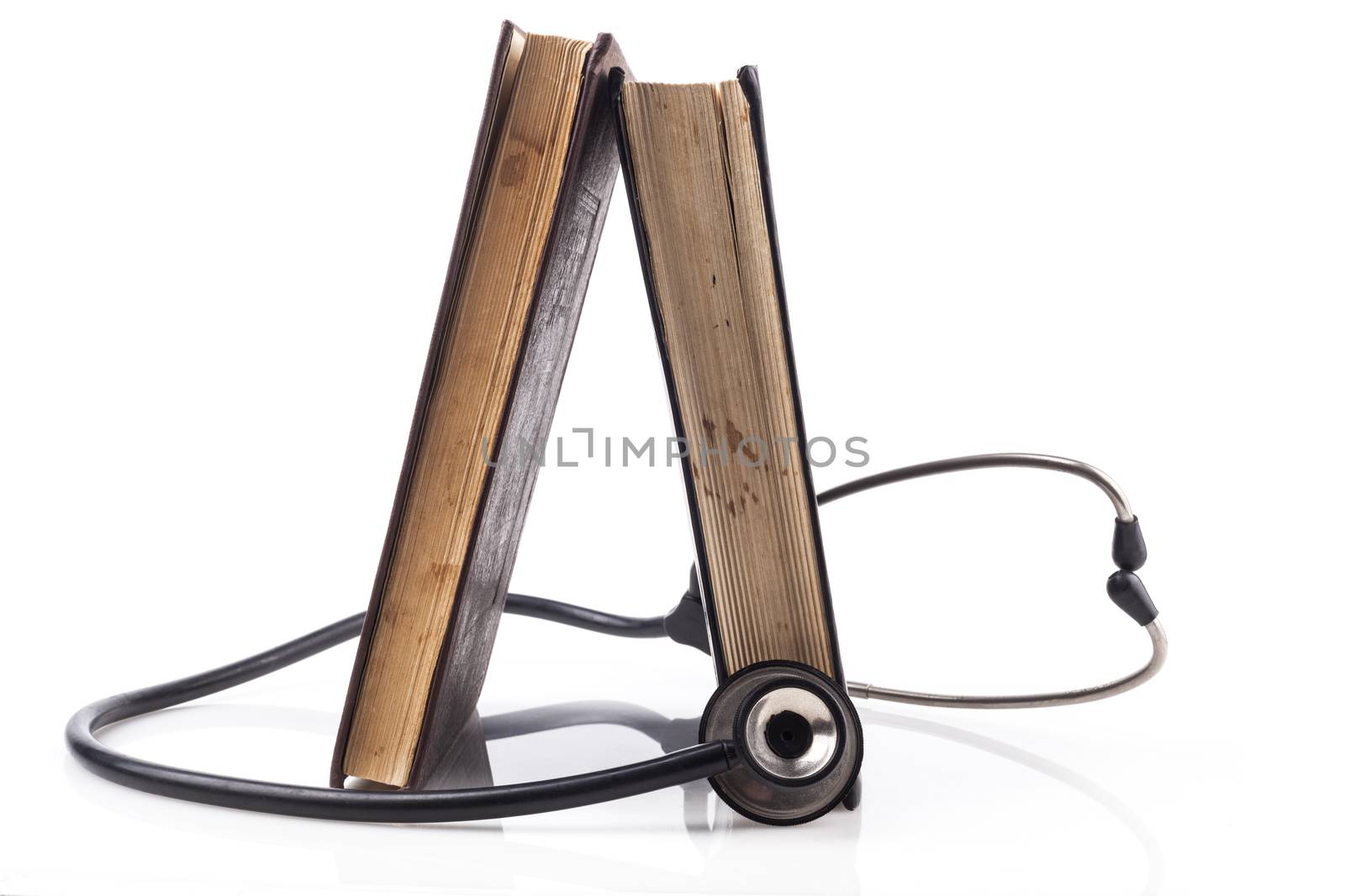 Two Books with black Stethoscope on white background with reflection