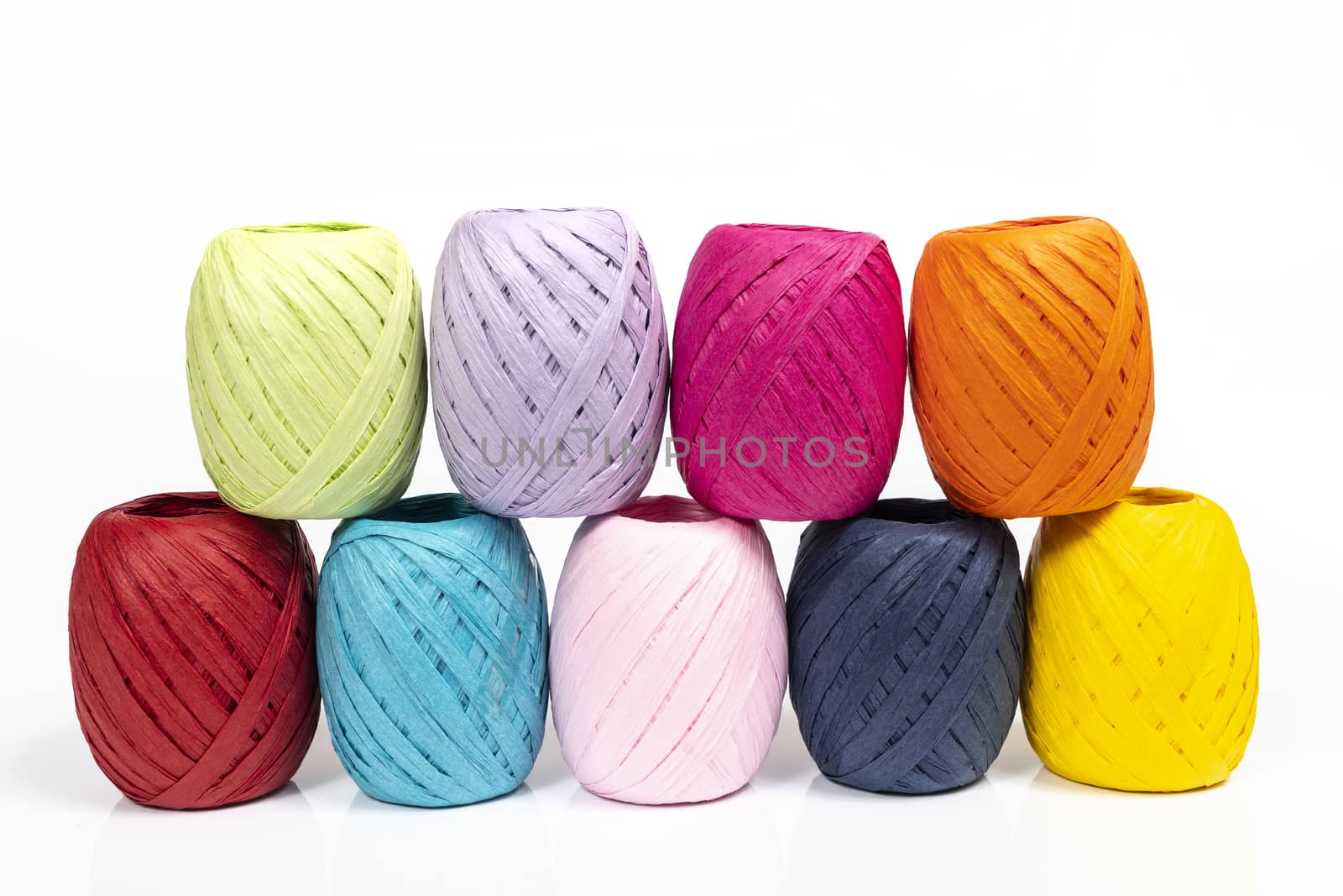 some balls of colored raffia on a white surface