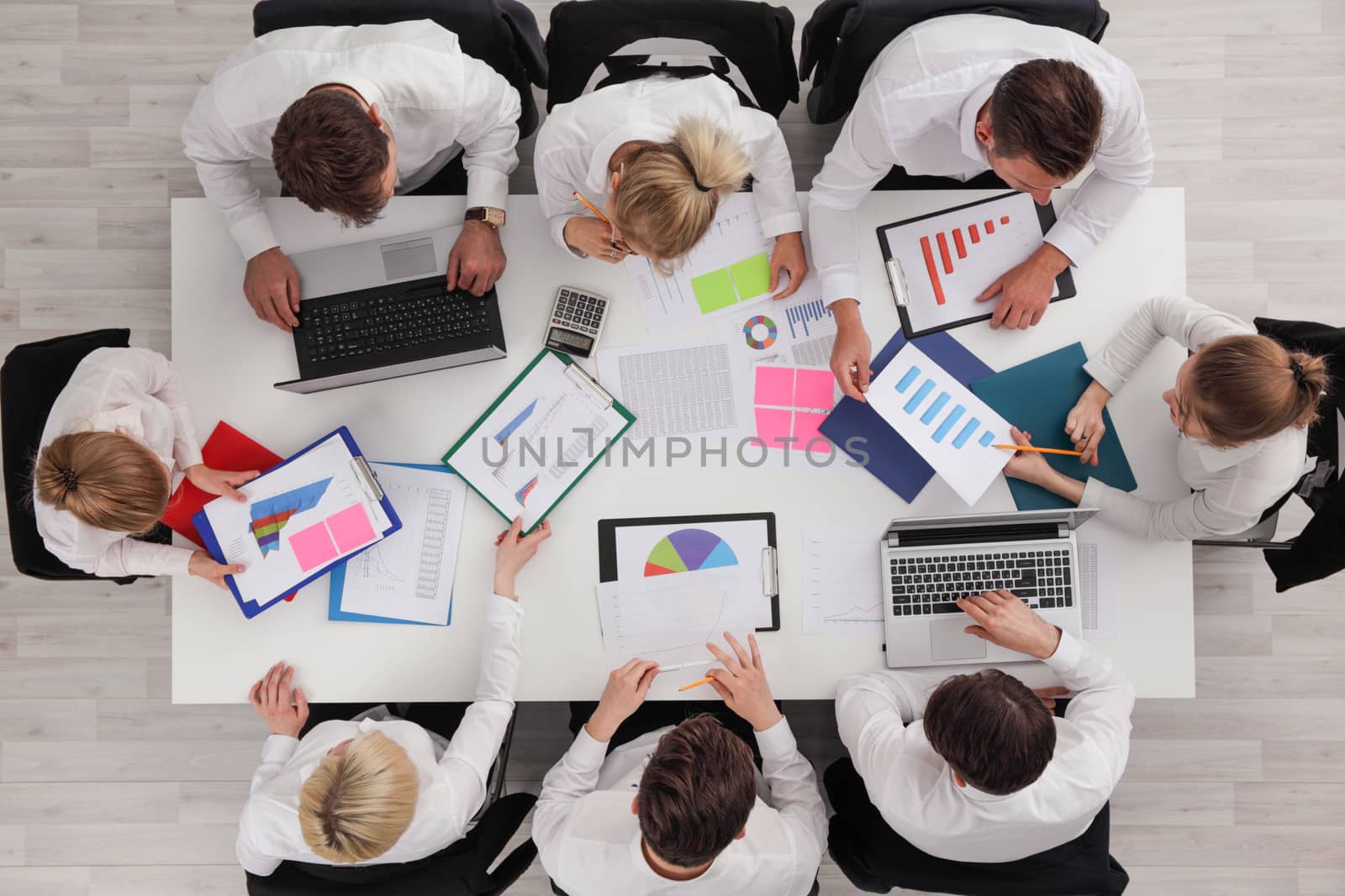 Business people meeting in the office top view , white collar workers discuss documents with diagrams and using laptop