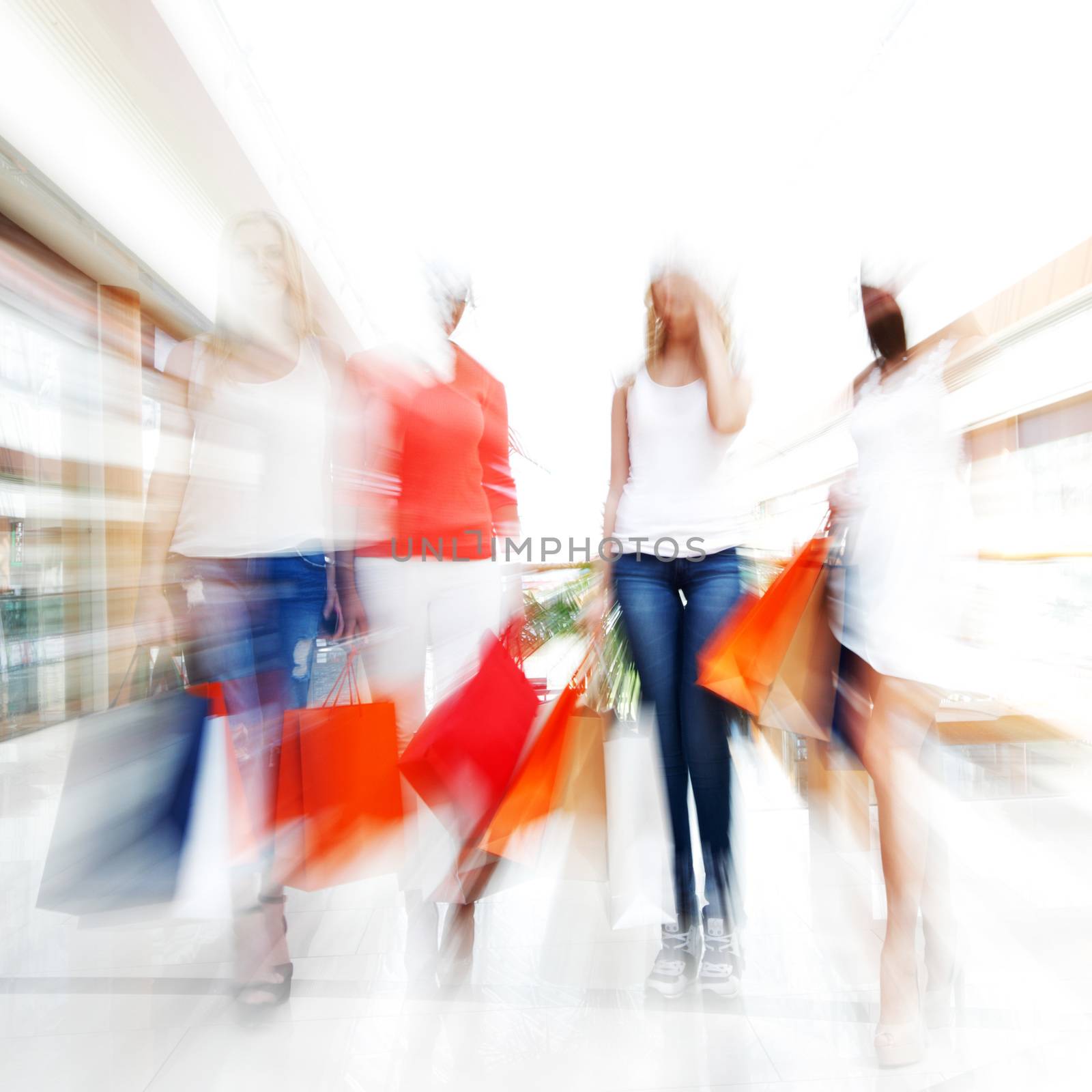 Women walking fast in shopping mall with bags , conceptual abstract background