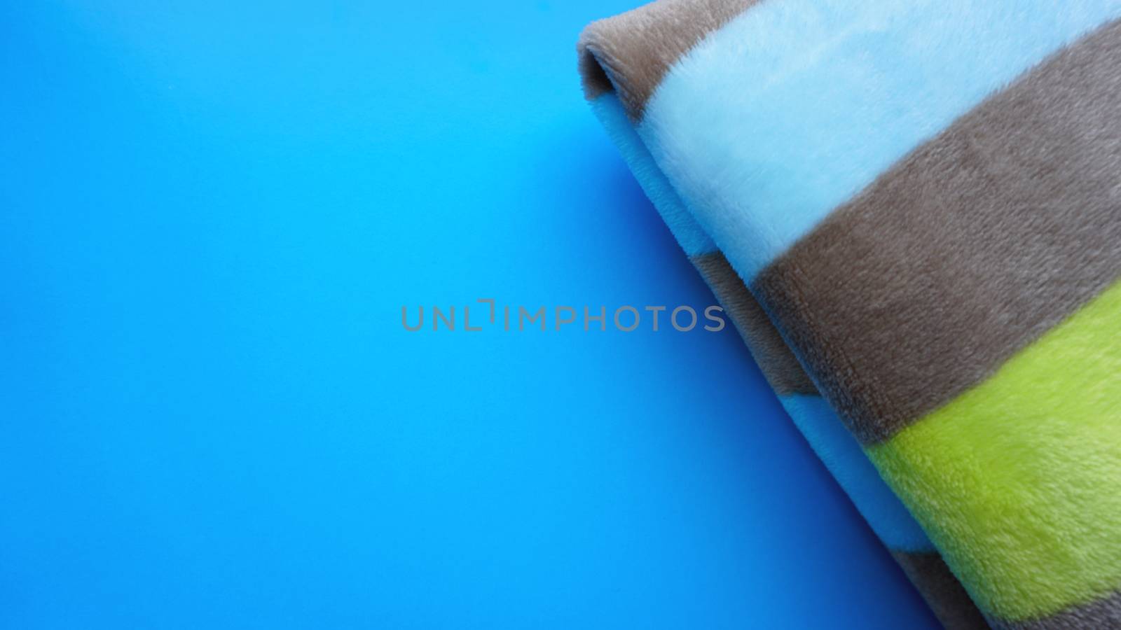 Soft blue blanket on blue background. Autumn comfort, space for text, top view by natali_brill