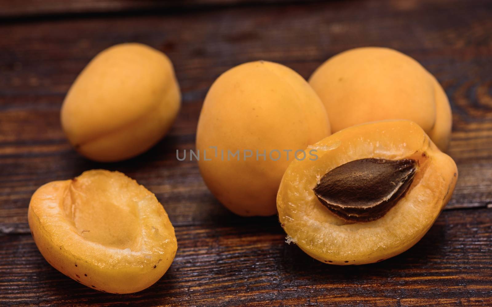 two half of apricot with pip on dark wooden background