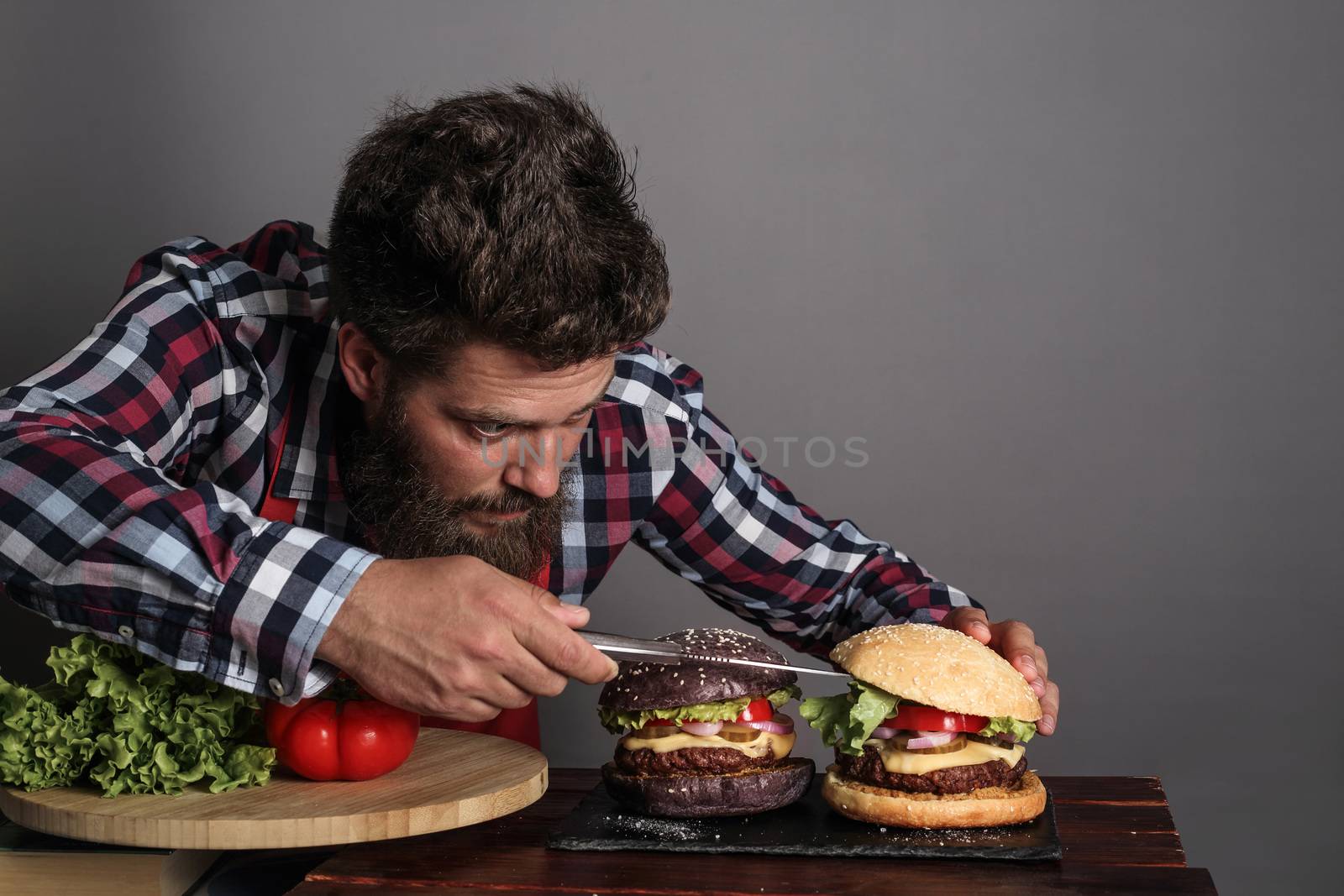Man cooking fresh self made black burger close up