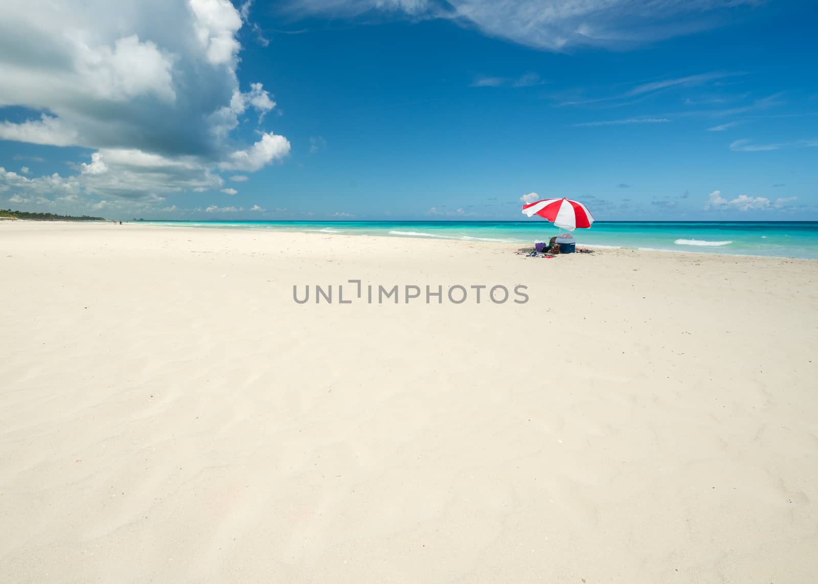 Wonderful  beach of Varadero during a sunny day, fine white sand and turquoise and green Caribbean sea,on the right one red parasol,Cuba.concept  photo,copy space.