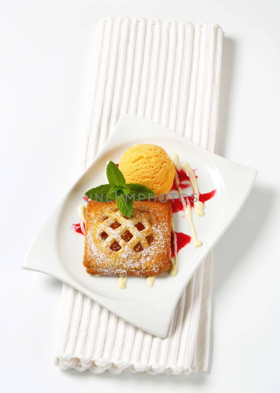 Little lattice-topped apricot pie with a scoop of ice cream