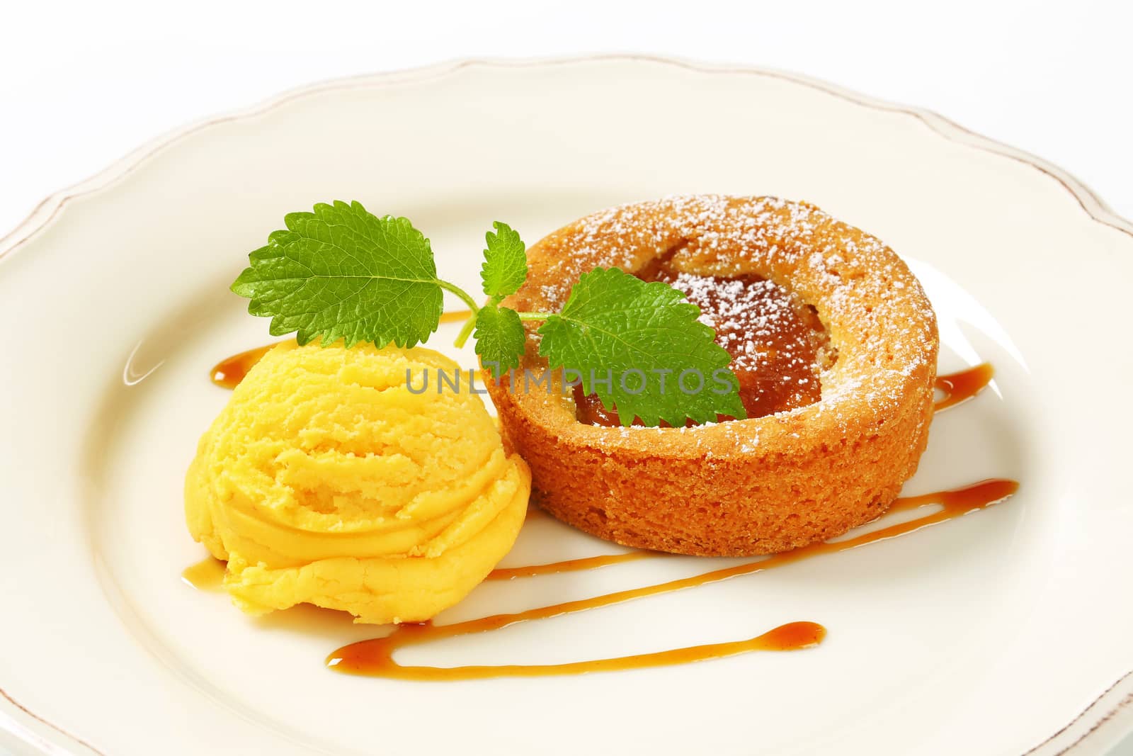 Small apple filled tart and scoop of yellow ice cream
