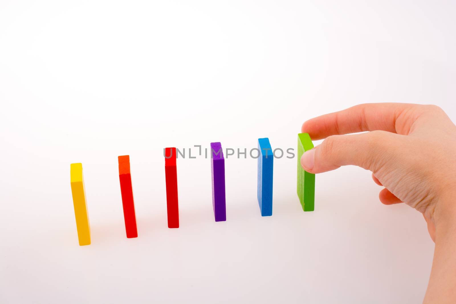 Hand playing with colored domino by berkay