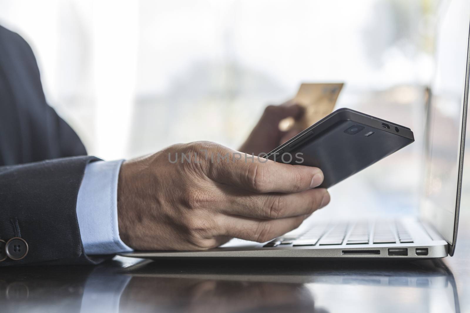 Man using laptop phone and credit card