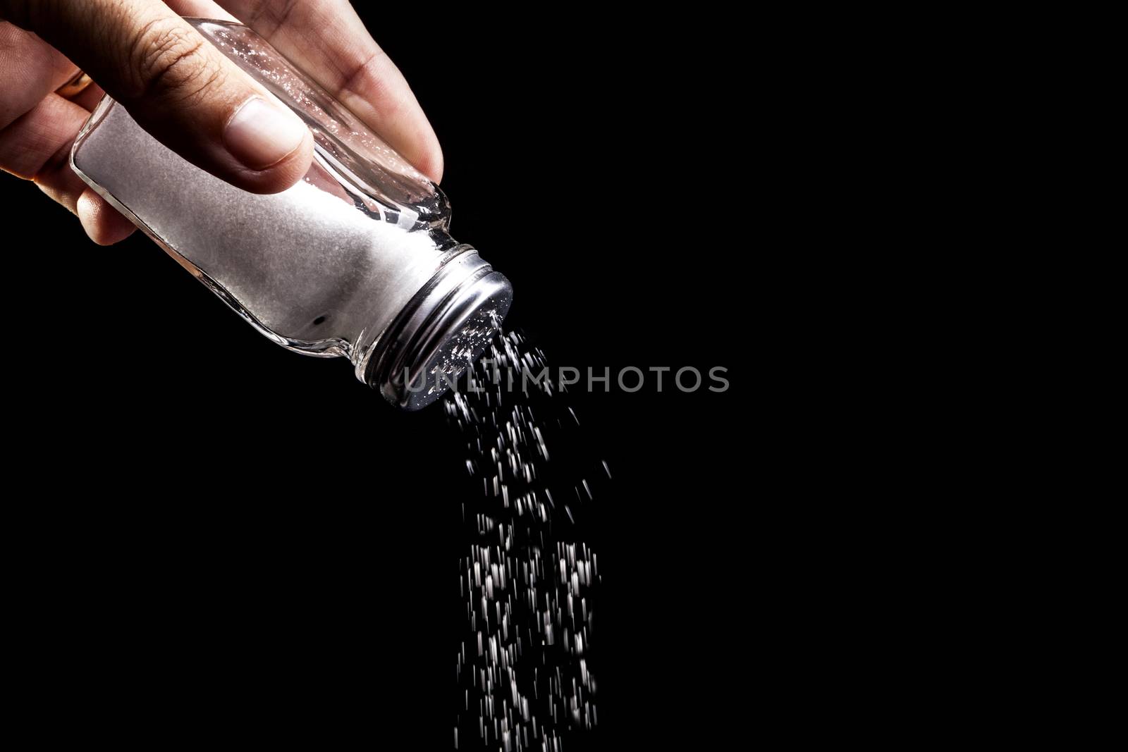 Hand and salt isolated on black background