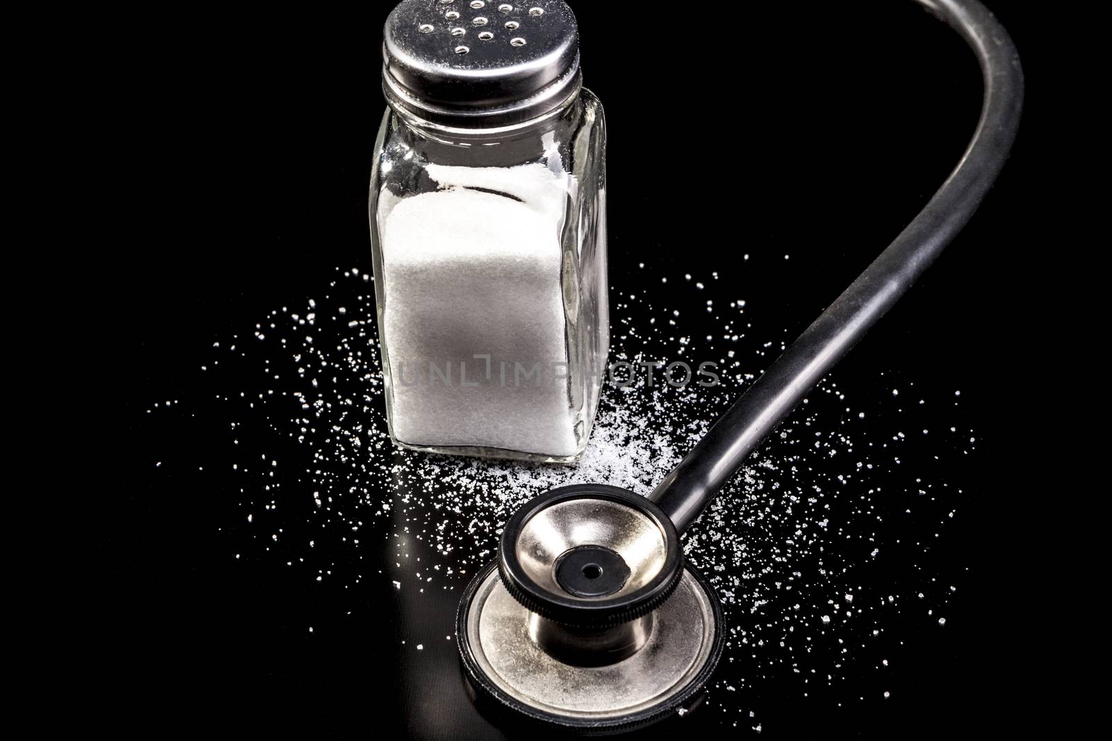 Medical instrument and salt isolated on black background with reflection