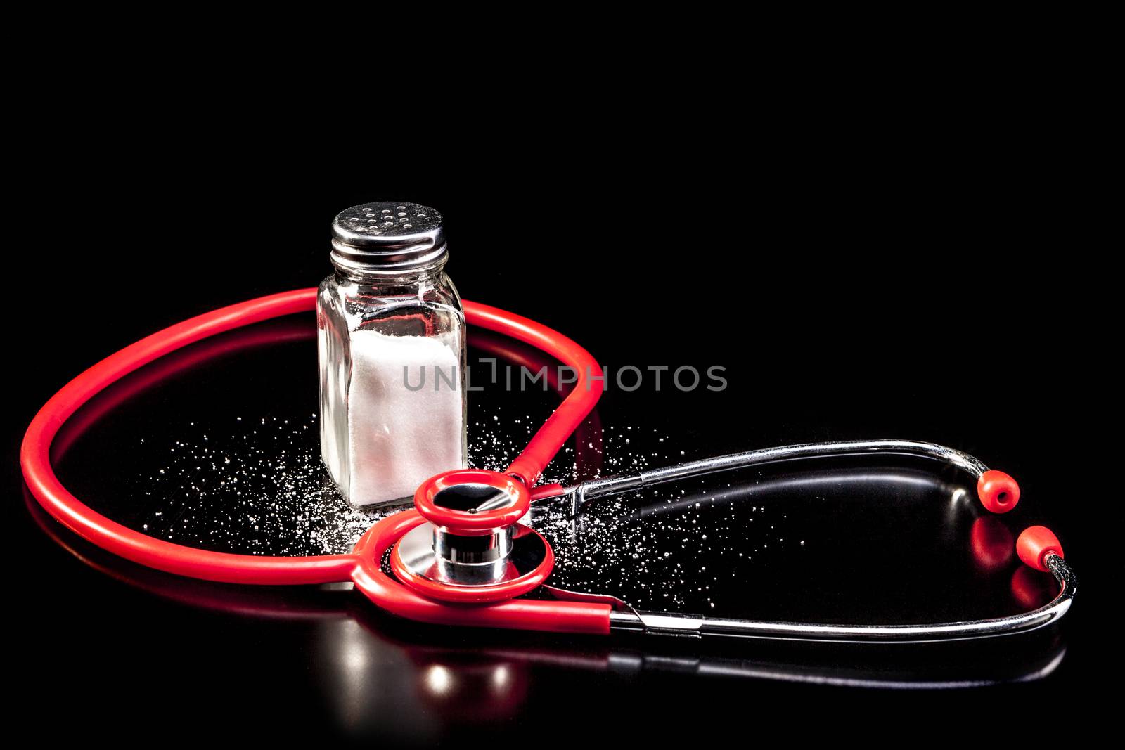 Medical instrument and salt isolated on black background with reflection