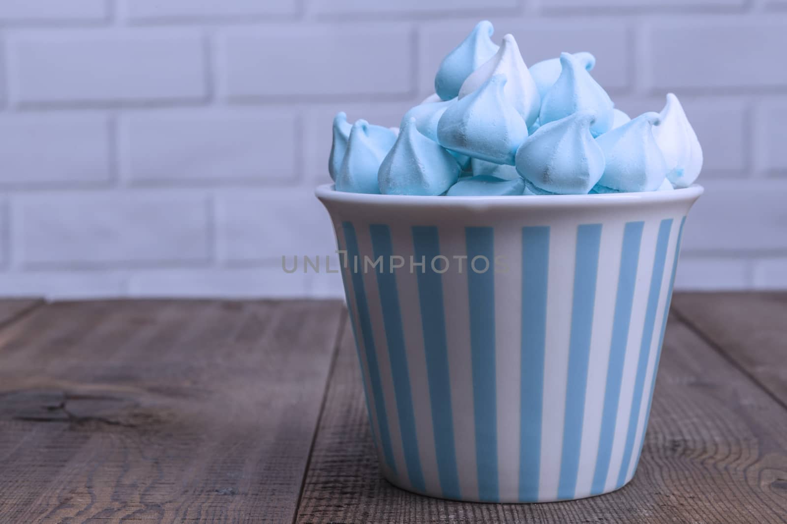 Blue sweets in a cup on wood table