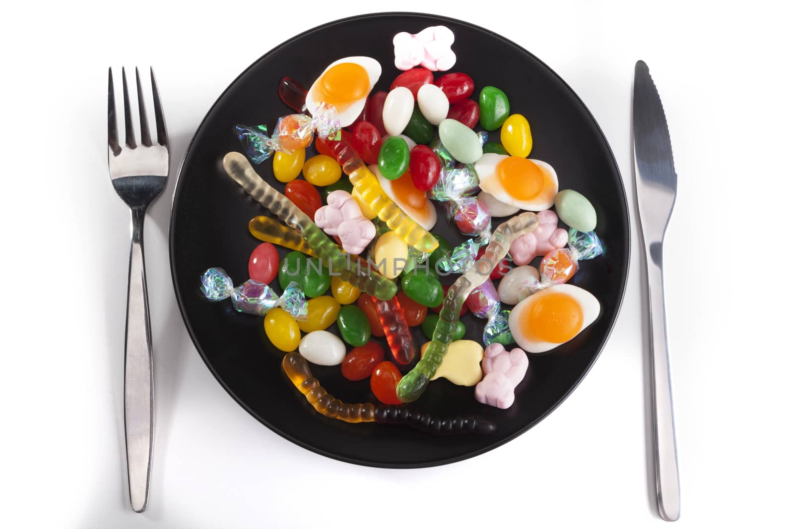 Plate with candies isolated on white background with shadow