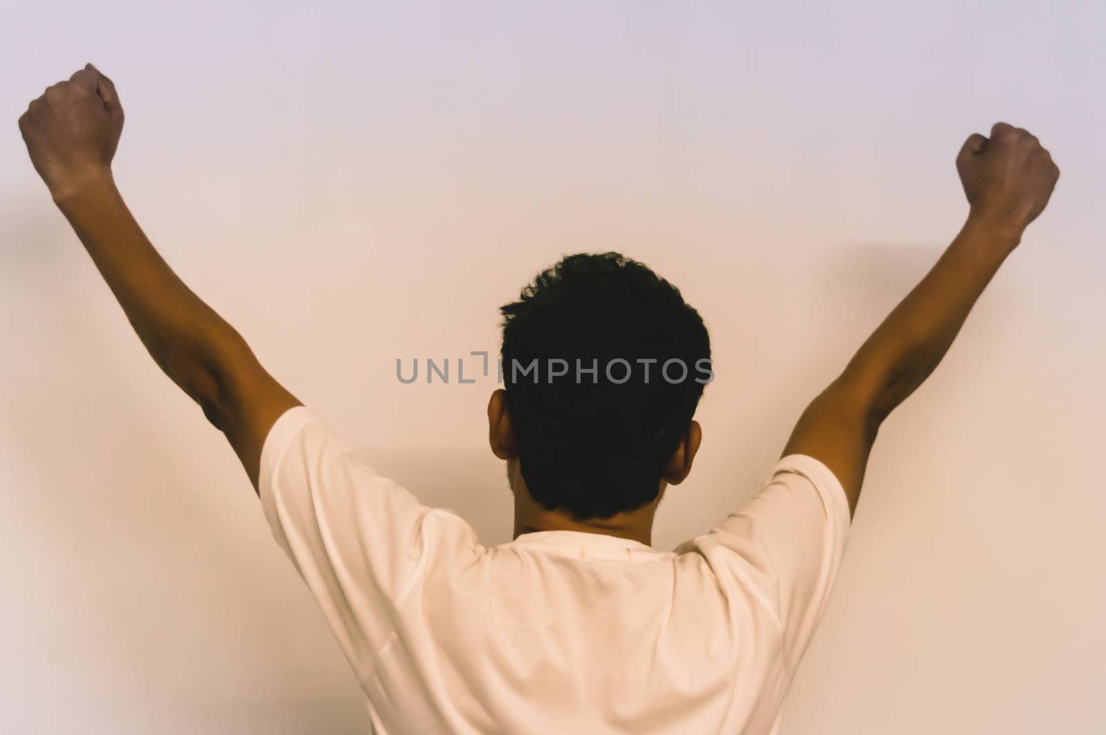 Studio shot of modern hipster young man with hands up, back view. isolated on white background by sudiptabhowmick