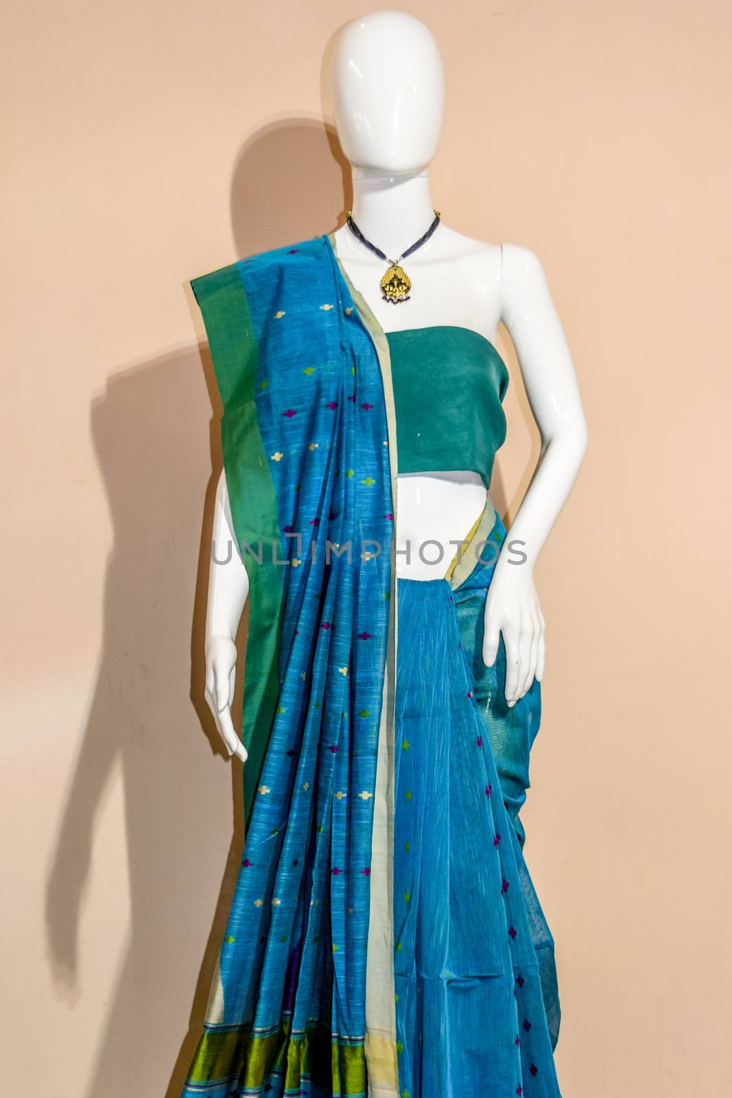 A traditional indian colorful silk saree displayed for sale. Selective focus on model face