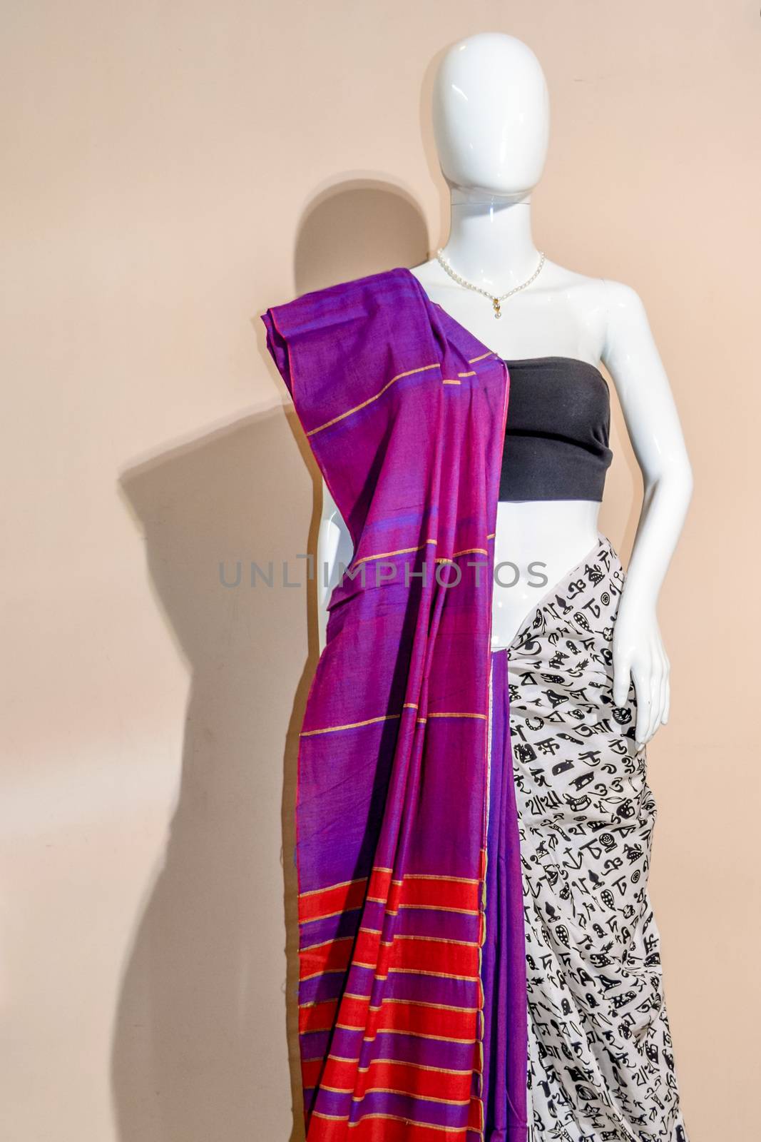 A traditional indian colorful silk saree displayed for sale. Selective focus on model face