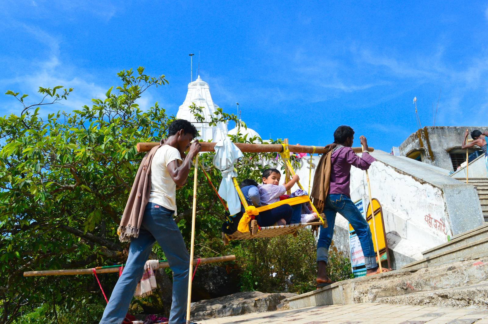 KEDARNATH, AMARNATH, INDIA- OCTOBER, 2017: Kashmiri porters carry Tourists seated in sedan chair during 3-day Himalayan pilgrimage to worship Shiva in a hilly area of ancient Amarnath Cave temple.