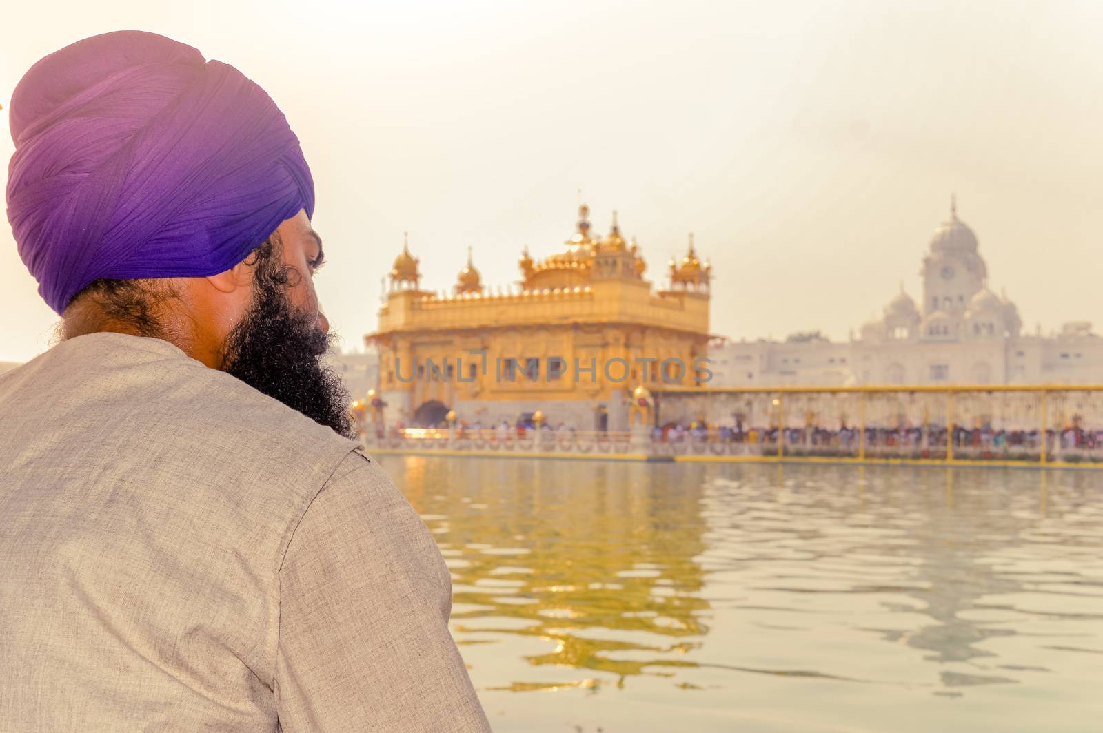 Unidentifiable Punjabi Sikh pilgrim devotee "Nihang Warrior" sitting by the pool and meditating in front of Golden Temple ("Harmandir Sahib Darbar Gurudwara") Amritsar, Punjab, India, Asia.