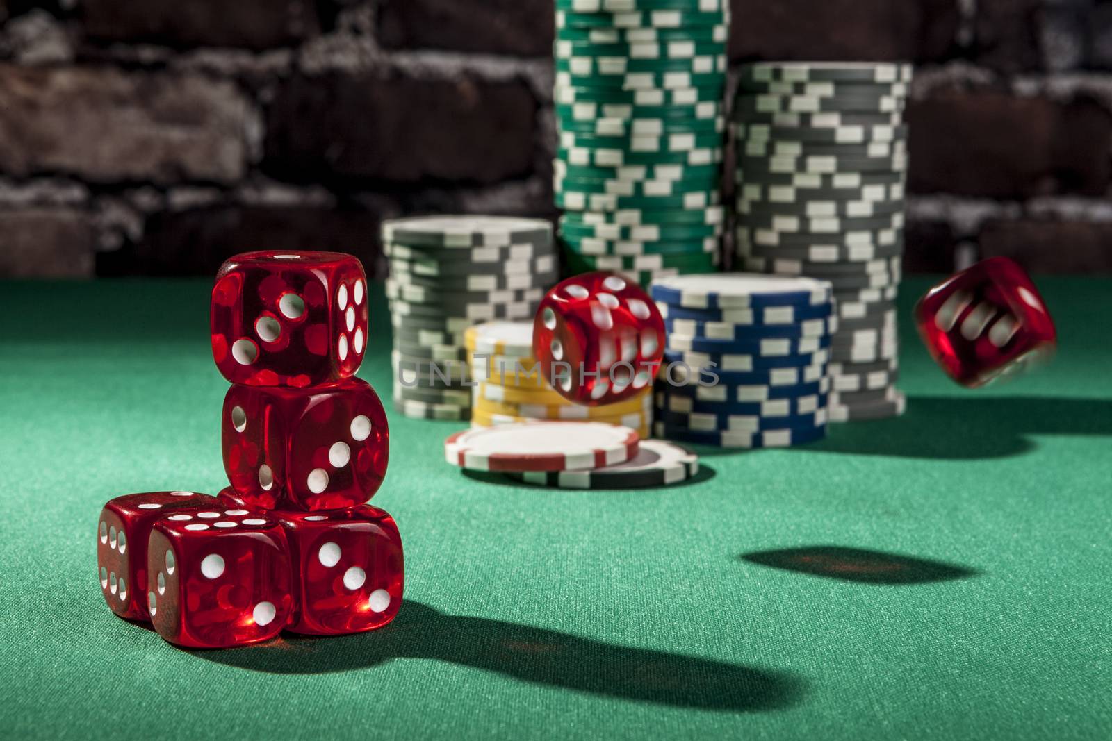 Red dice and chips on green table