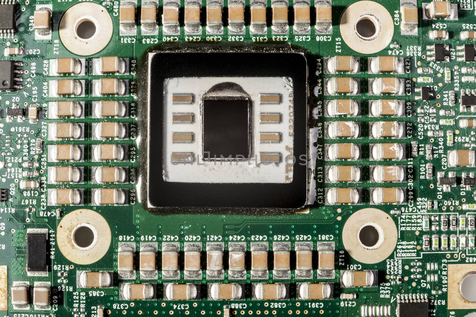 Small electronic components on green circuit board macro closeup