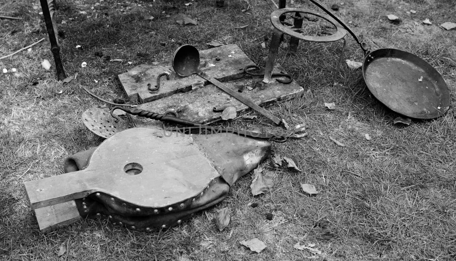 Bellows, ladle, poker and frying pan - authentic campfire details at a Medieval Fair - monochrome processing