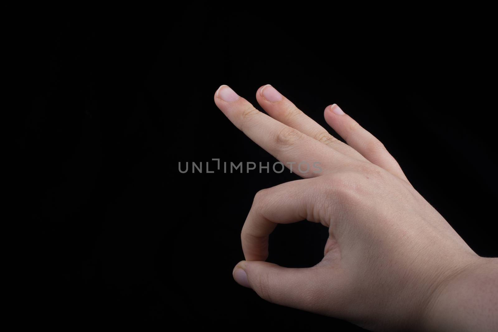 Hand gesturing sign ok okay agree on  black background