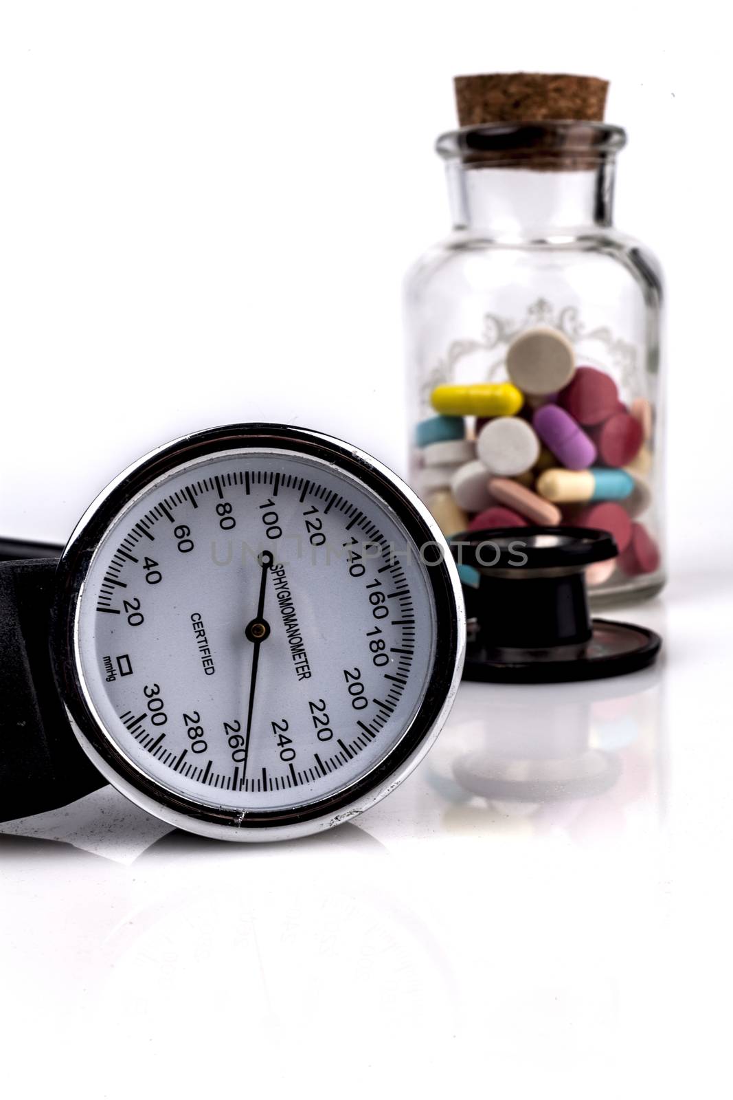 Colored Pills in a Jar with Sphygmomanometer and Black Stethoscope