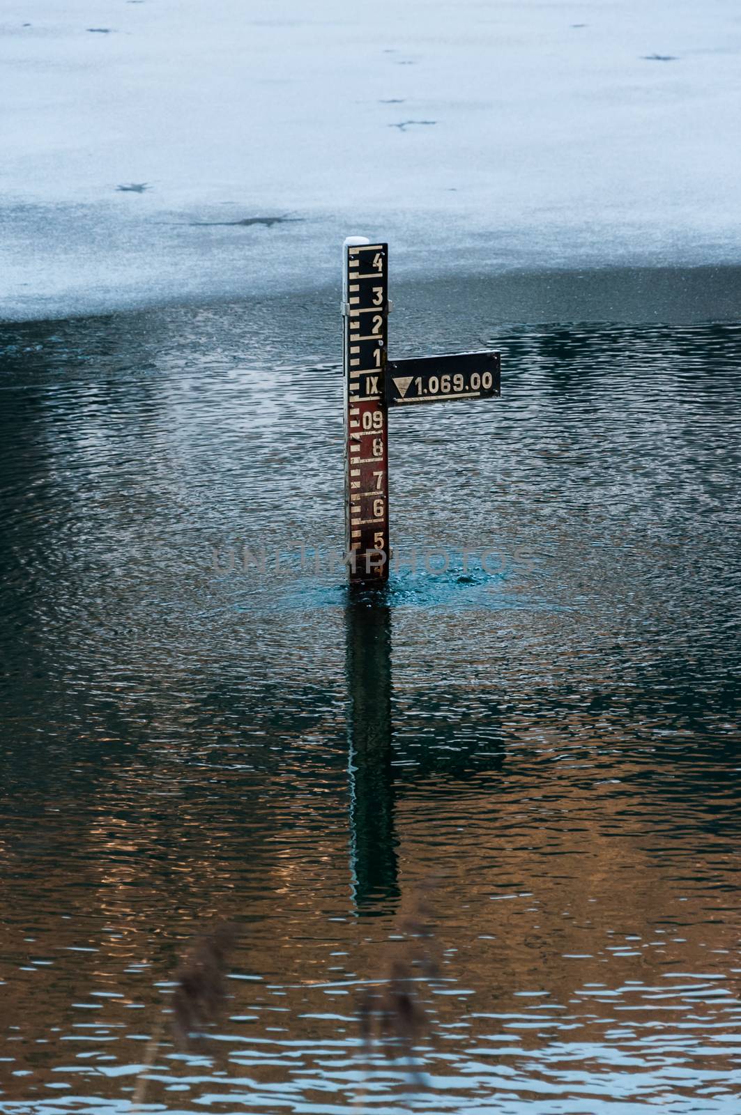 water depth measurement tool in mountains partially iced lake in Tyrol (Austria)