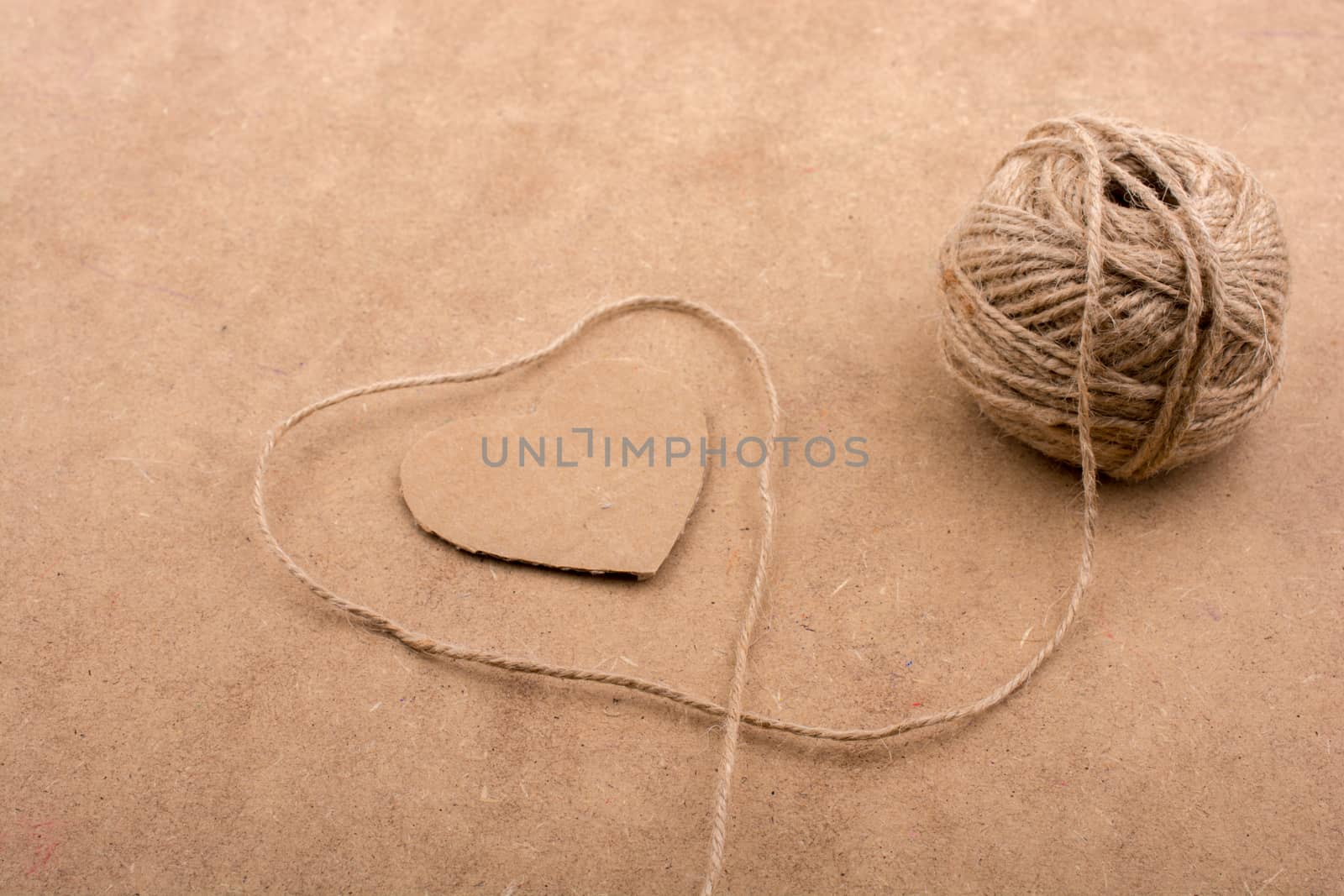 Thread off spool form a heart shape on brown background