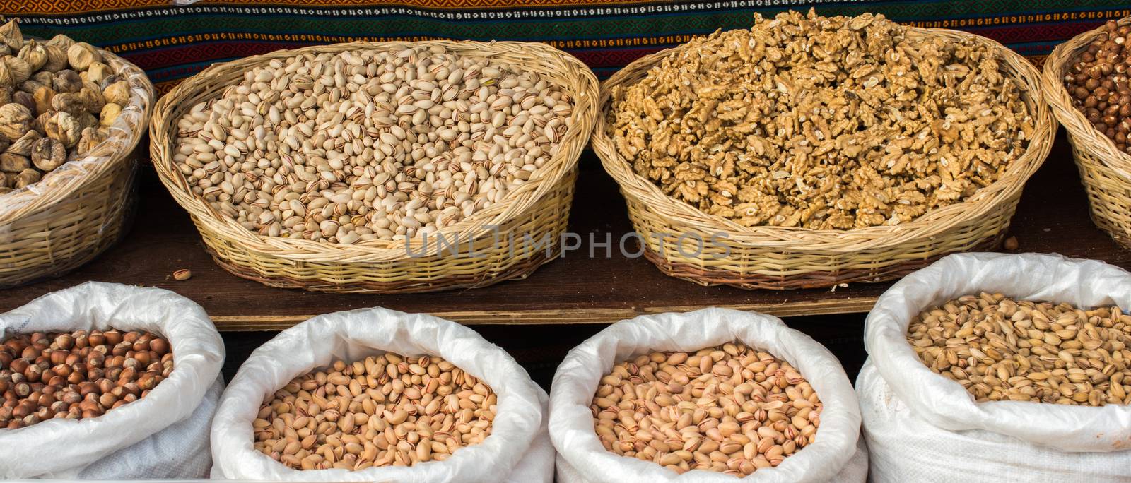 Walnuts, pistachios and hazelnuts in straw baskets and sacks on display