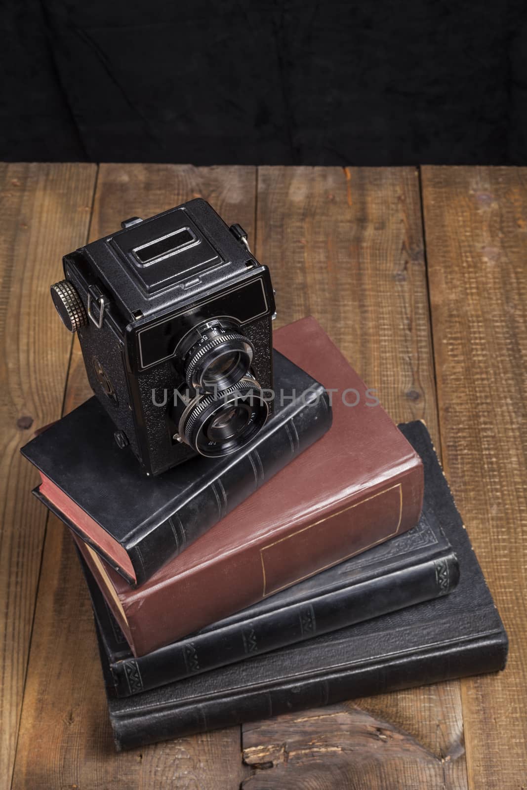 Old Camera Closeup on old Books and Brown Wood Background